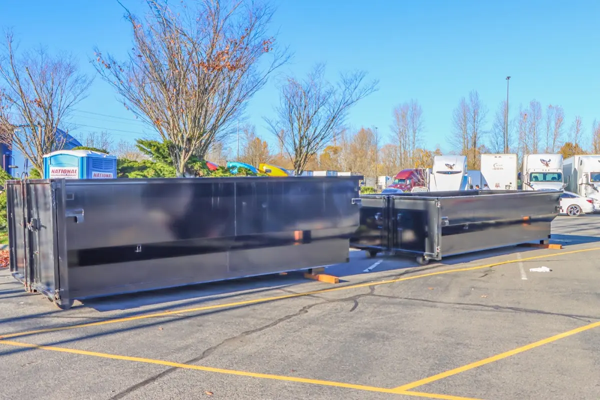 Professional dumpster rental service with roll-off container on residential driveway in Camp Swift